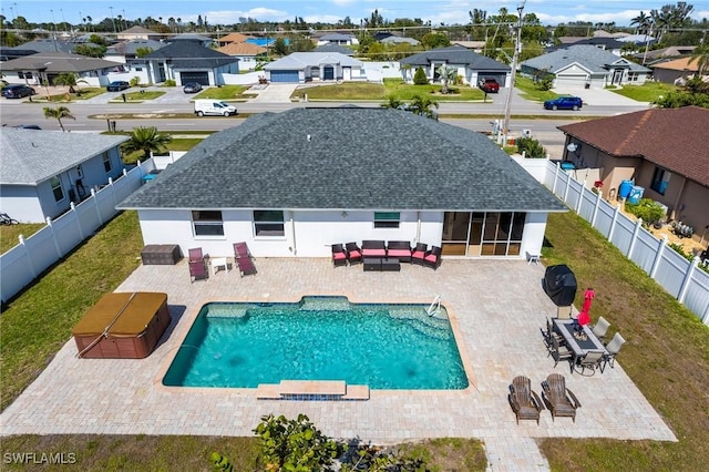 view of swimming pool featuring a hot tub, an outdoor hangout area, a patio area, a residential view, and a fenced backyard