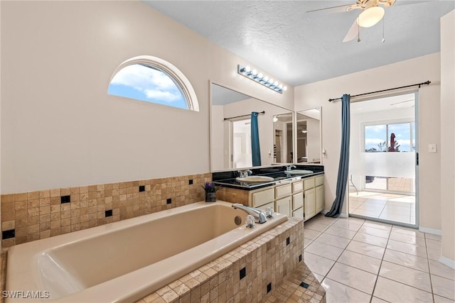 full bathroom featuring ceiling fan, a textured ceiling, a sink, tile patterned floors, and double vanity