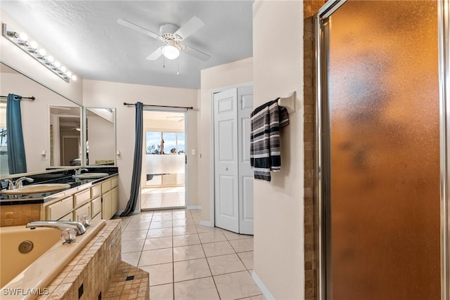 bathroom with a ceiling fan, a closet, a sink, and tile patterned floors