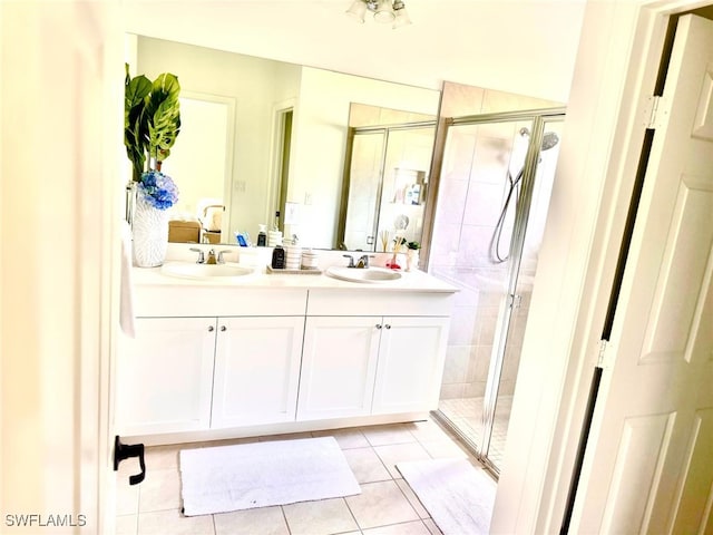 bathroom with tile patterned flooring, vanity, and walk in shower