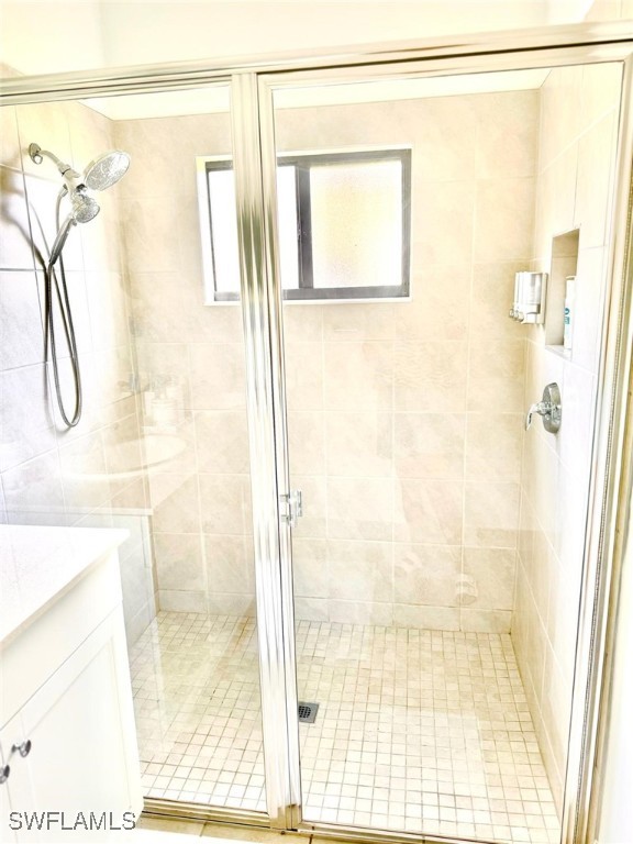 bathroom featuring vanity and a shower with door