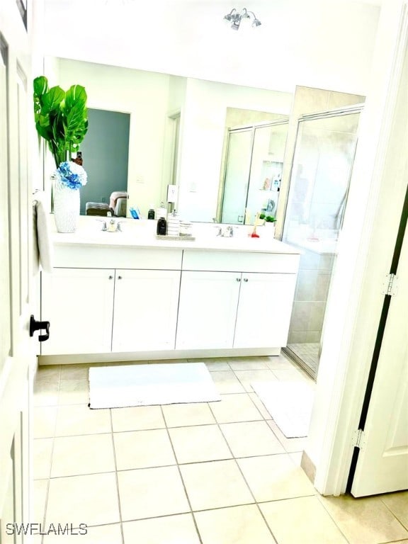 bathroom featuring tile patterned floors, vanity, and a shower with shower door