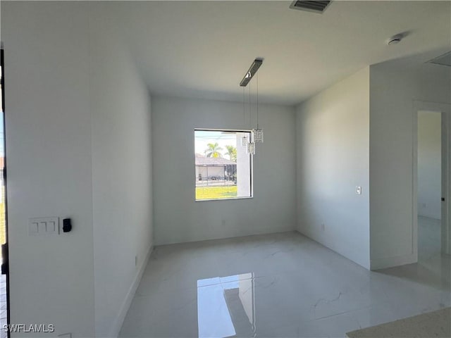 spare room with marble finish floor and visible vents