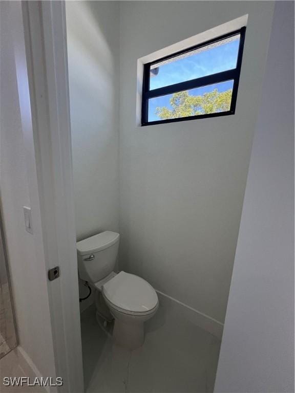 bathroom featuring toilet and baseboards