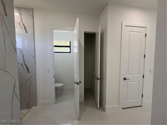 bathroom with marble finish floor, baseboards, and toilet