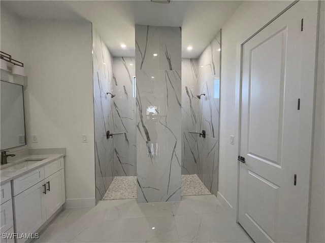 bathroom featuring marble finish floor, a marble finish shower, baseboards, and vanity