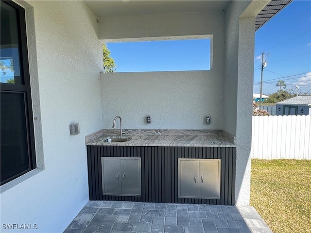 view of patio / terrace featuring a sink, area for grilling, and fence