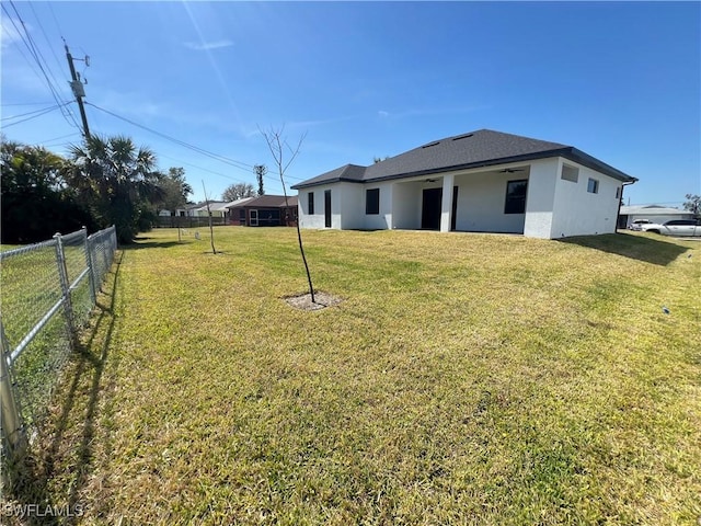 view of yard with fence and a ceiling fan