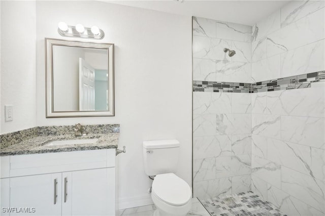 full bathroom featuring marble finish floor, tiled shower, vanity, and toilet