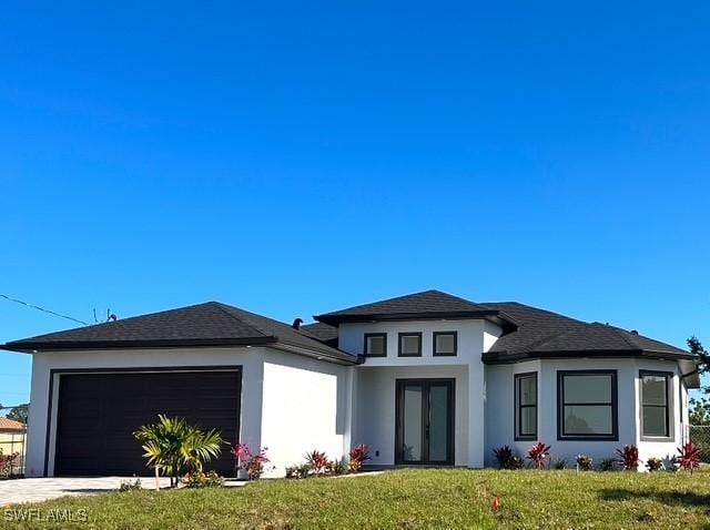 prairie-style house featuring a garage and a front yard