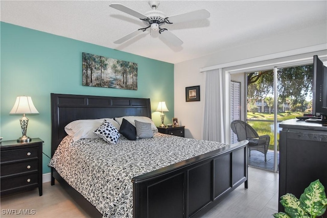 bedroom with access to outside, light wood-style flooring, and a ceiling fan