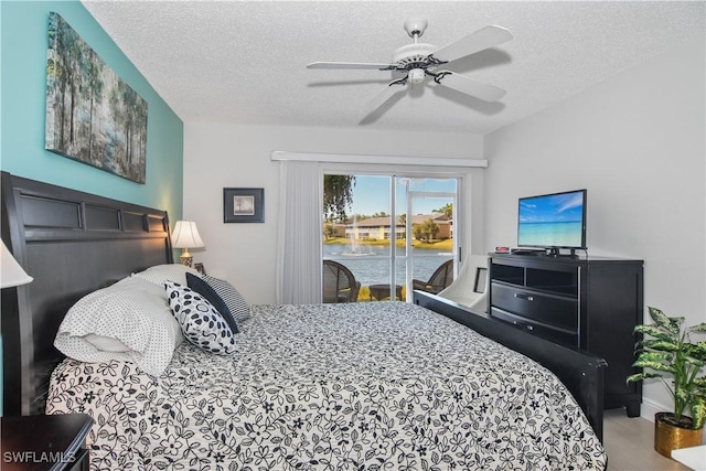 bedroom featuring access to exterior, a ceiling fan, and a textured ceiling