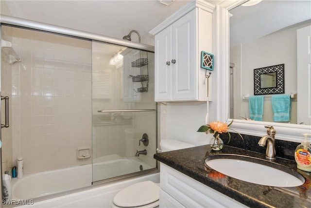 bathroom with shower / bath combination with glass door, vanity, and toilet