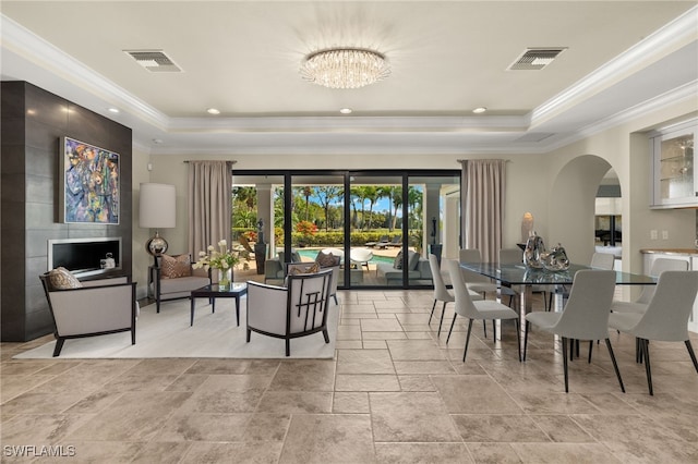 dining area with visible vents, ornamental molding, a tray ceiling, and stone tile flooring