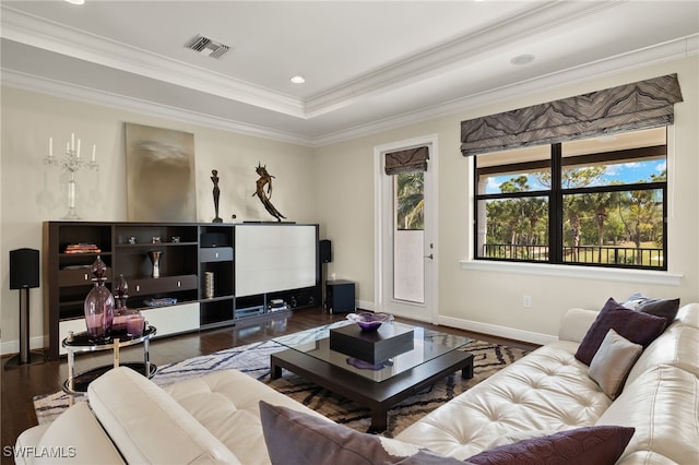 living area featuring a raised ceiling, baseboards, visible vents, ornamental molding, and hardwood / wood-style flooring