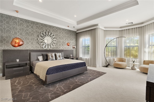 bedroom with visible vents, ornamental molding, a tray ceiling, and wallpapered walls