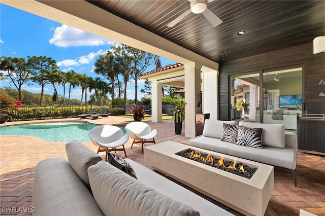 view of patio featuring fence, ceiling fan, a fenced in pool, and an outdoor living space with a fire pit