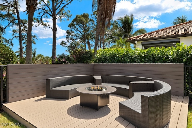 wooden deck featuring an outdoor living space with a fire pit