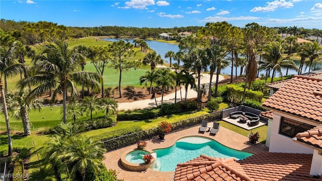 view of pool with a fenced backyard, a water view, a pool with connected hot tub, and a patio area