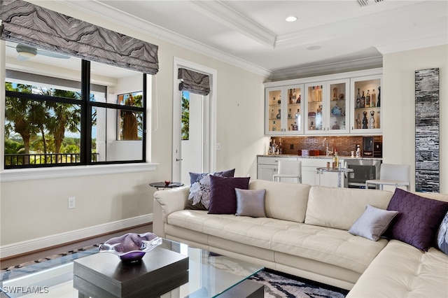 living room with crown molding, recessed lighting, wet bar, baseboards, and visible vents