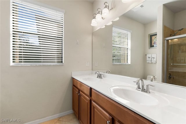 bathroom featuring toilet, vanity, tile patterned flooring, and a shower with shower door