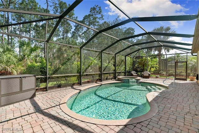 view of pool featuring an in ground hot tub, glass enclosure, and a patio area