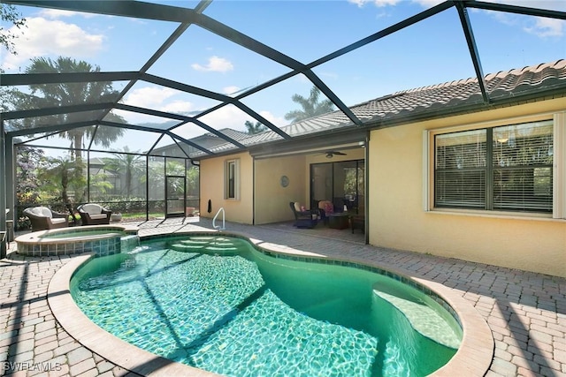 view of pool featuring a patio, ceiling fan, an in ground hot tub, and glass enclosure