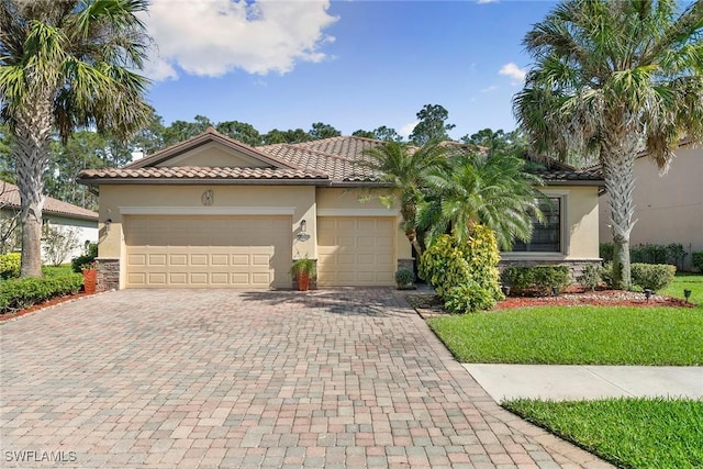 3915 Treasure Cove Cir, Naples, FL 34114 - mediterranean / spanish home featuring a tile roof, decorative driveway, stone siding, a garage, and stucco siding