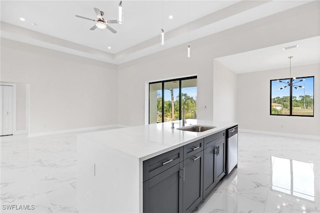 kitchen featuring open floor plan, a sink, marble finish floor, light countertops, and stainless steel dishwasher