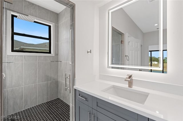 full bathroom with tiled shower and vanity