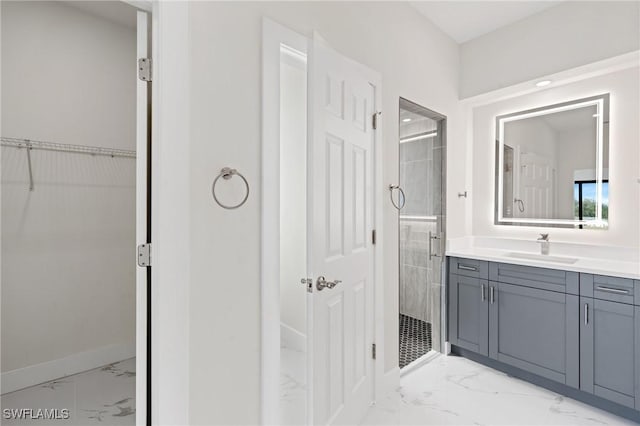 bathroom with marble finish floor, a shower stall, and vanity