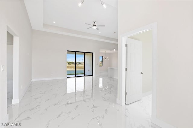 empty room with recessed lighting, marble finish floor, baseboards, and ceiling fan with notable chandelier