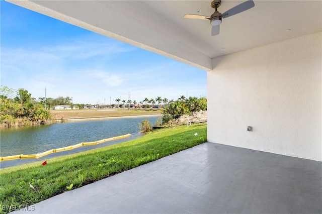 view of patio with a water view and ceiling fan