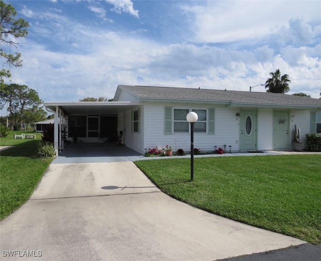 single story home with concrete driveway, an attached carport, and a front yard