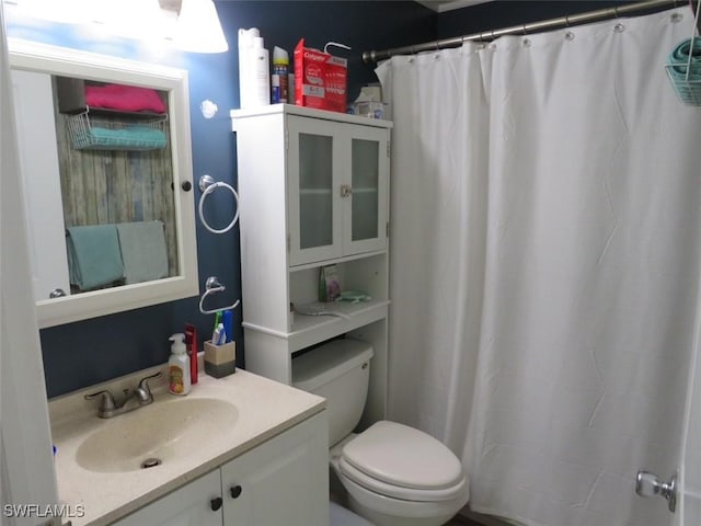 full bath with curtained shower, vanity, and toilet