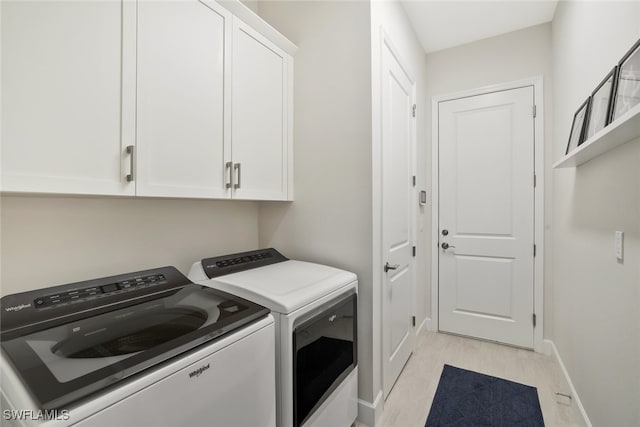 washroom featuring light hardwood / wood-style floors, cabinets, and separate washer and dryer