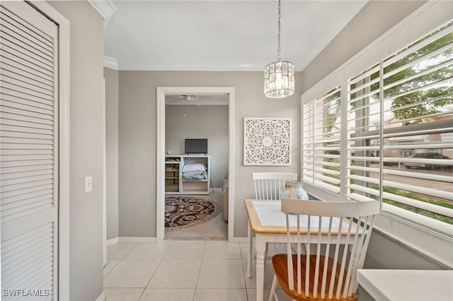 interior space featuring an inviting chandelier, crown molding, baseboards, and light tile patterned floors