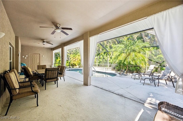 view of patio / terrace featuring ceiling fan and glass enclosure