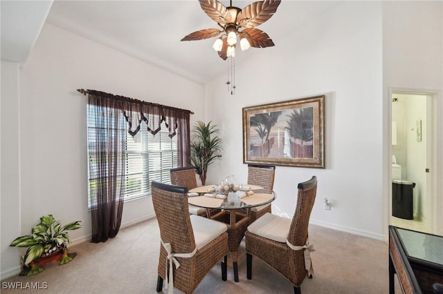 dining area featuring lofted ceiling, ceiling fan, and light colored carpet