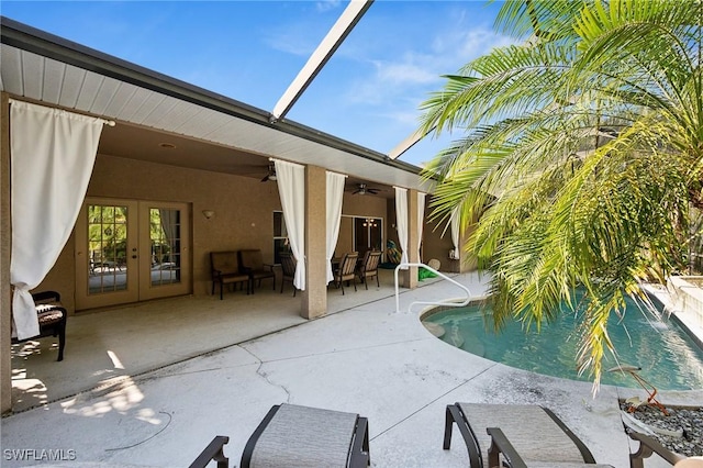 view of swimming pool featuring french doors, a patio, a lanai, and ceiling fan