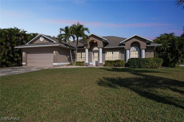 ranch-style home featuring a garage and a yard