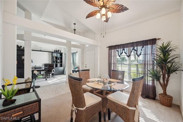 dining area featuring lofted ceiling, ceiling fan, and light tile patterned floors