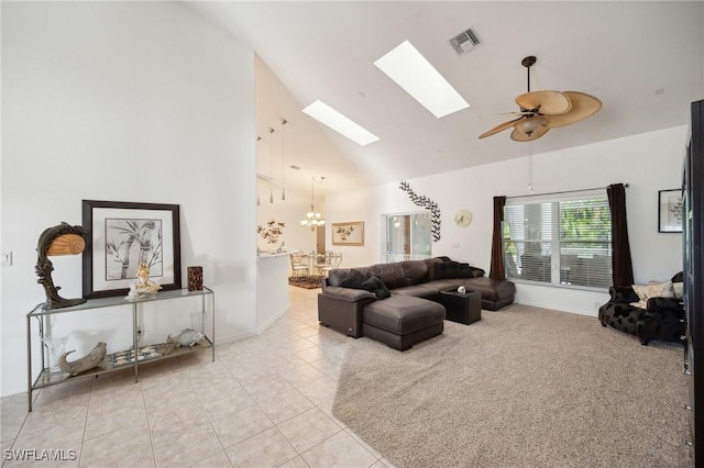 living room with ceiling fan with notable chandelier, high vaulted ceiling, light tile patterned floors, and a skylight