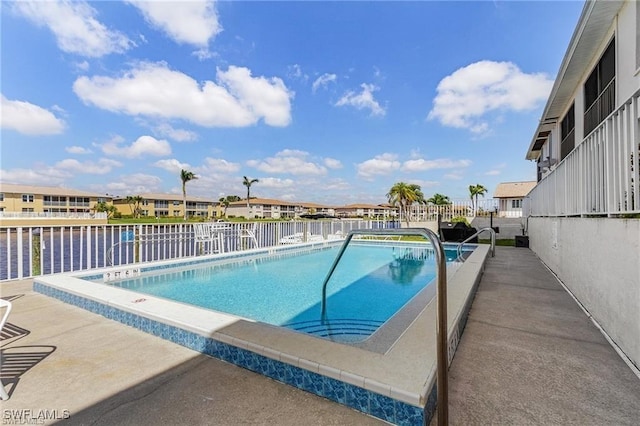 view of pool featuring a patio and a water view