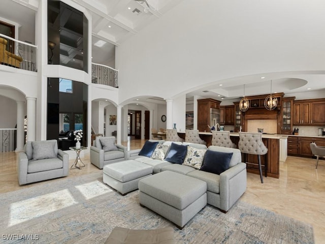 living room with beamed ceiling, decorative columns, recessed lighting, arched walkways, and marble finish floor