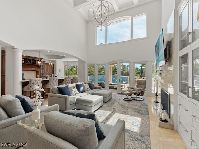 living area featuring coffered ceiling, beam ceiling, arched walkways, french doors, and a chandelier