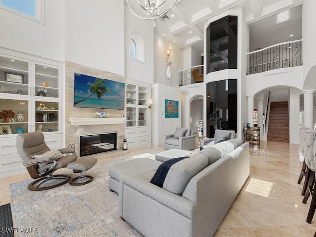 living room featuring arched walkways, a chandelier, a fireplace, and built in features