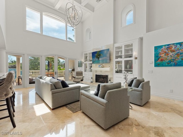 living area with a tiled fireplace, a healthy amount of sunlight, french doors, and an inviting chandelier