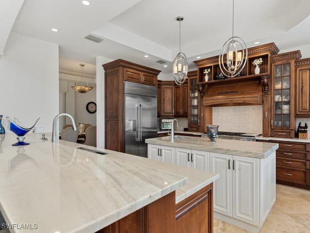 kitchen with premium range hood, visible vents, a center island with sink, appliances with stainless steel finishes, and backsplash