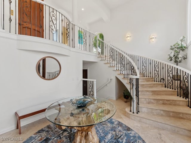 dining space with baseboards, a high ceiling, and stairs